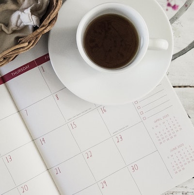 image of a calendar in a planner and a cup of coffee