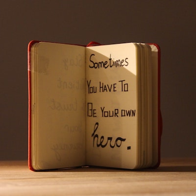 Image of a book with handwritten text "Sometimes you have to be your own hero."