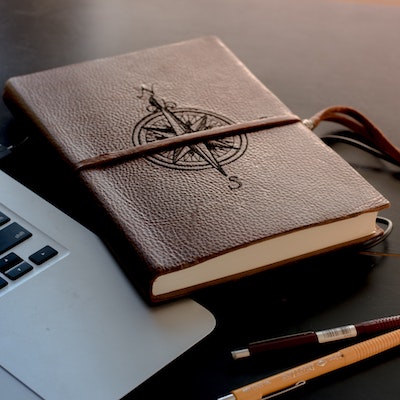 Image of a leather notebook with a compass on it